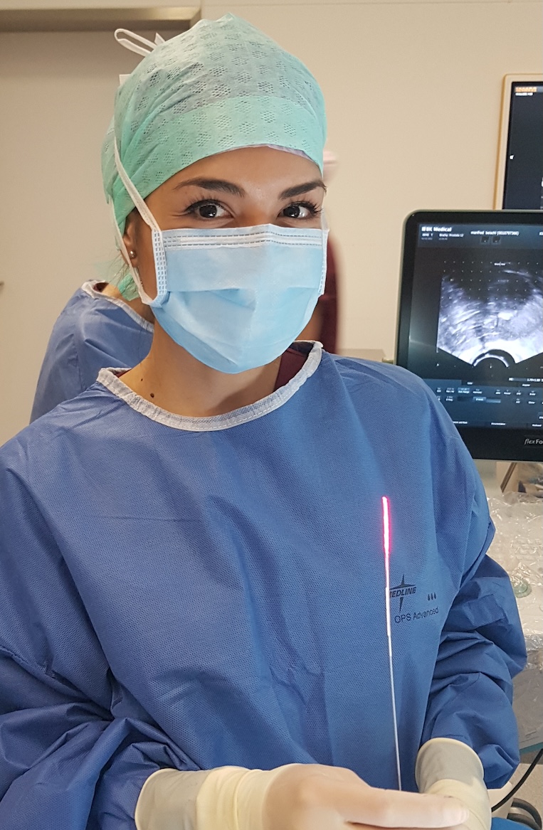 Nurse in operating room holding fiber optic in her hand.