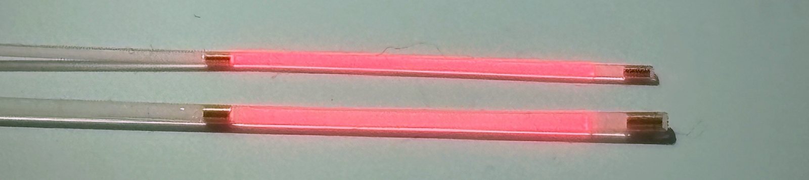 Cylindrical diffusers CD-2S3-20-MX and CD-4L3-20-MX emitting red light uniformly along their 20 mm diffusing sections