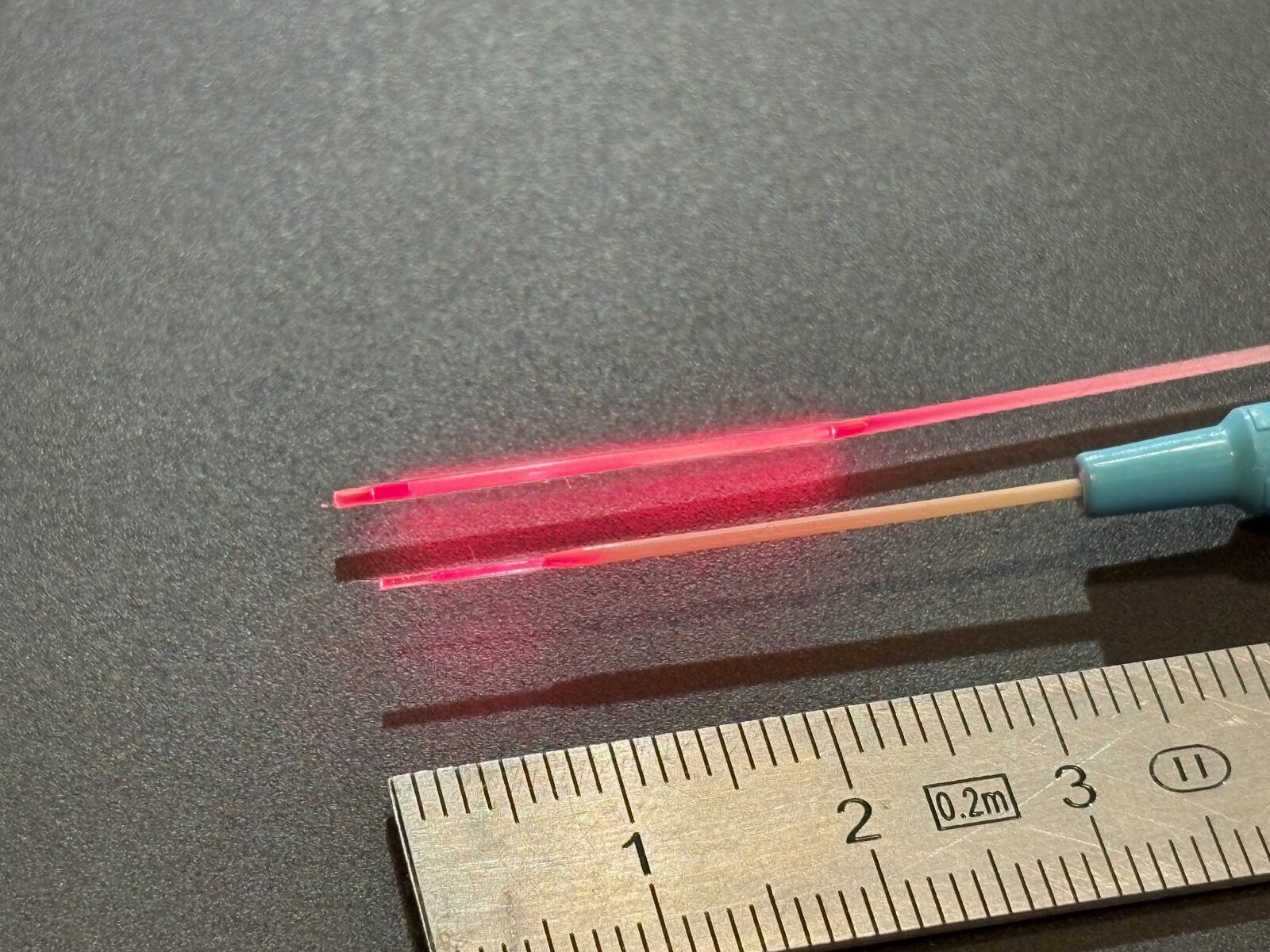 Size comparison: clinical diffuser CD-2S3 (top) and ultra-thin CD-2XS2-05 in a 22G cannula (bottom), with centimetre scale