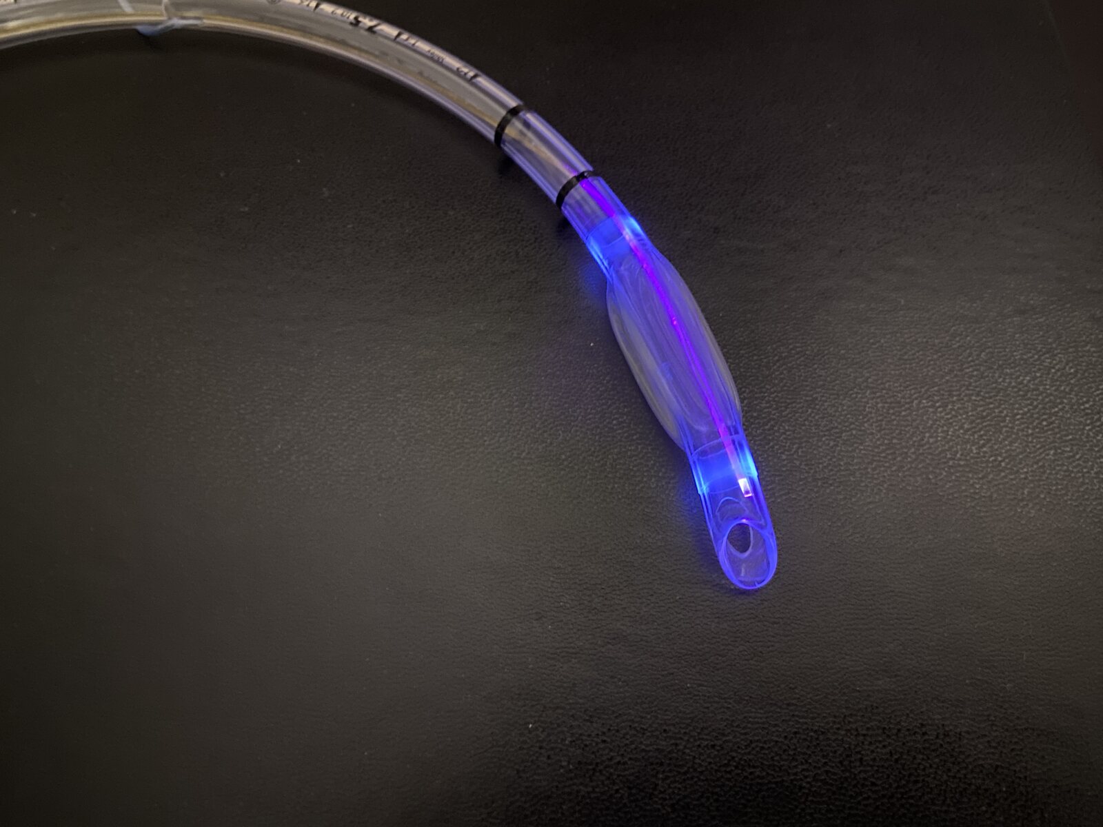 Endotracheal tube with integrated cylindrical diffuser emitting violet-blue light around the cuff